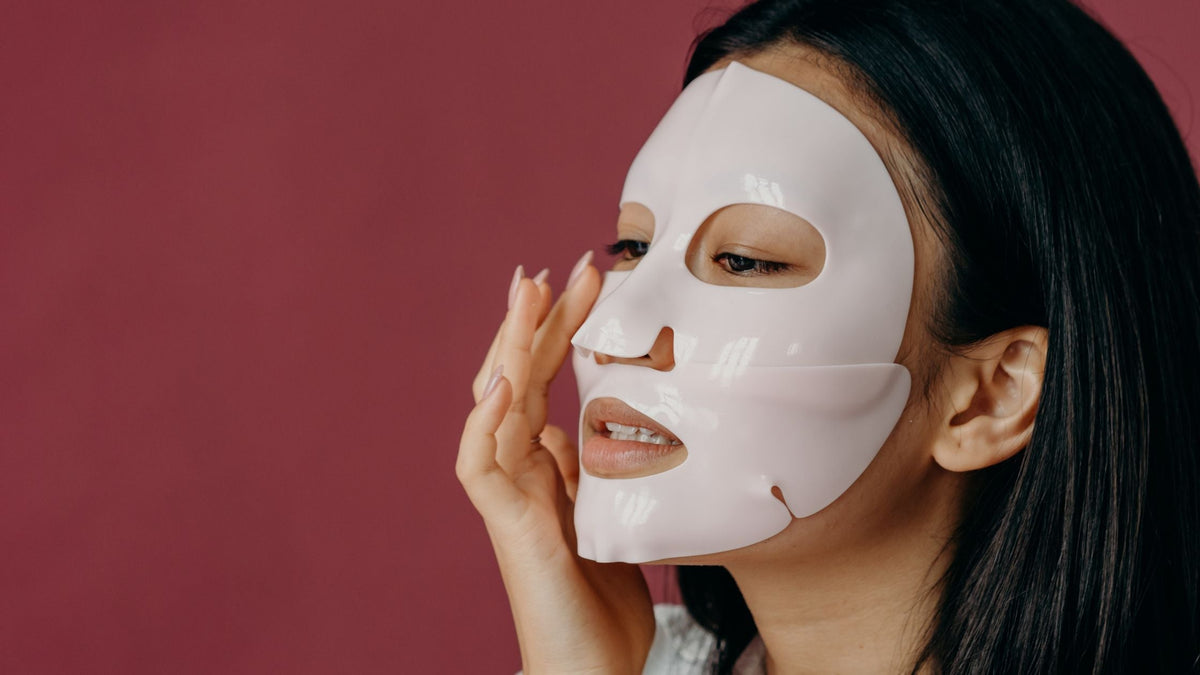 A Woman Touching Her Face with Sheet Mask
