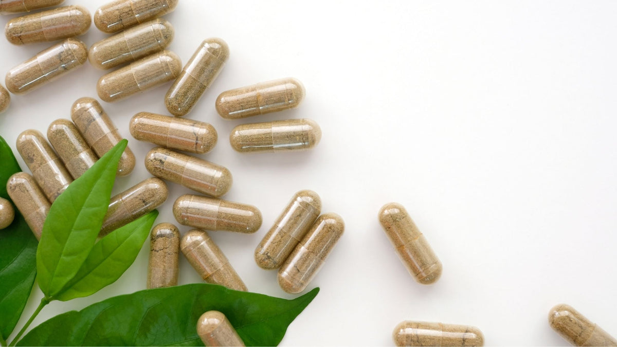 Collagen Supplement Capsules spilled on surface with green leaf
