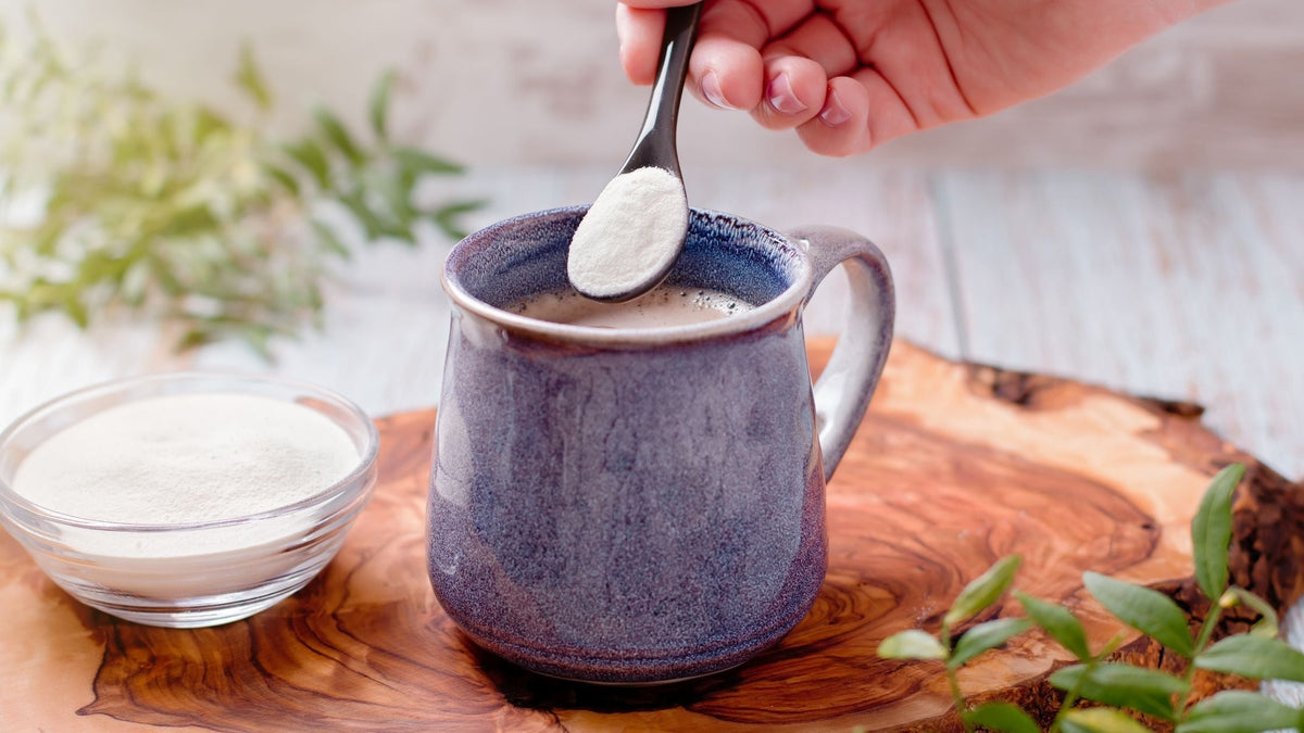 Hand Adding Collagen Powder to Morning Coffee