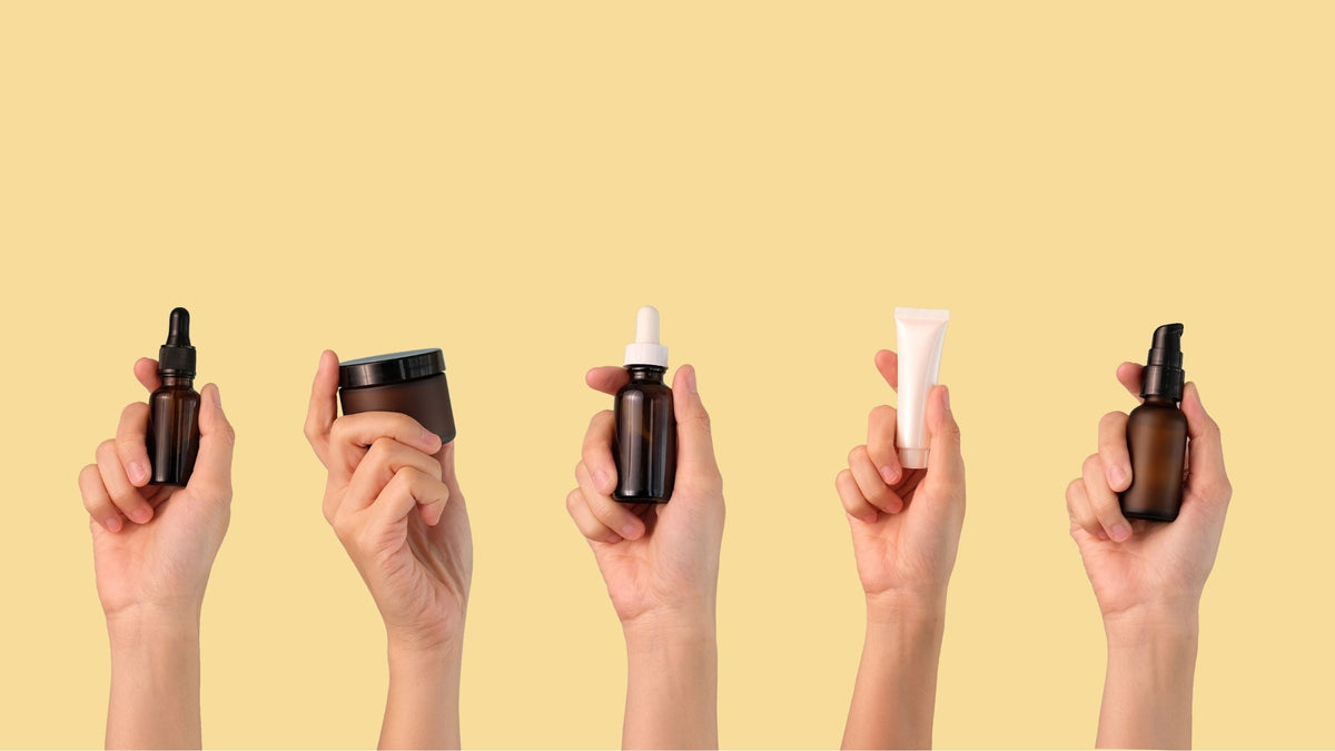 Hands Holding Assorted Skincare Products Routine