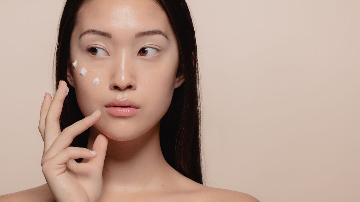 Korean skincare woman applying cream onto face