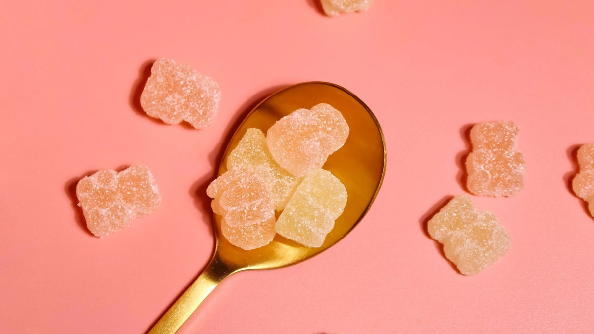 Orange collagen gummy bear gummies supplements on golden spoon