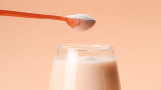 Scoop of collagen powder above drink