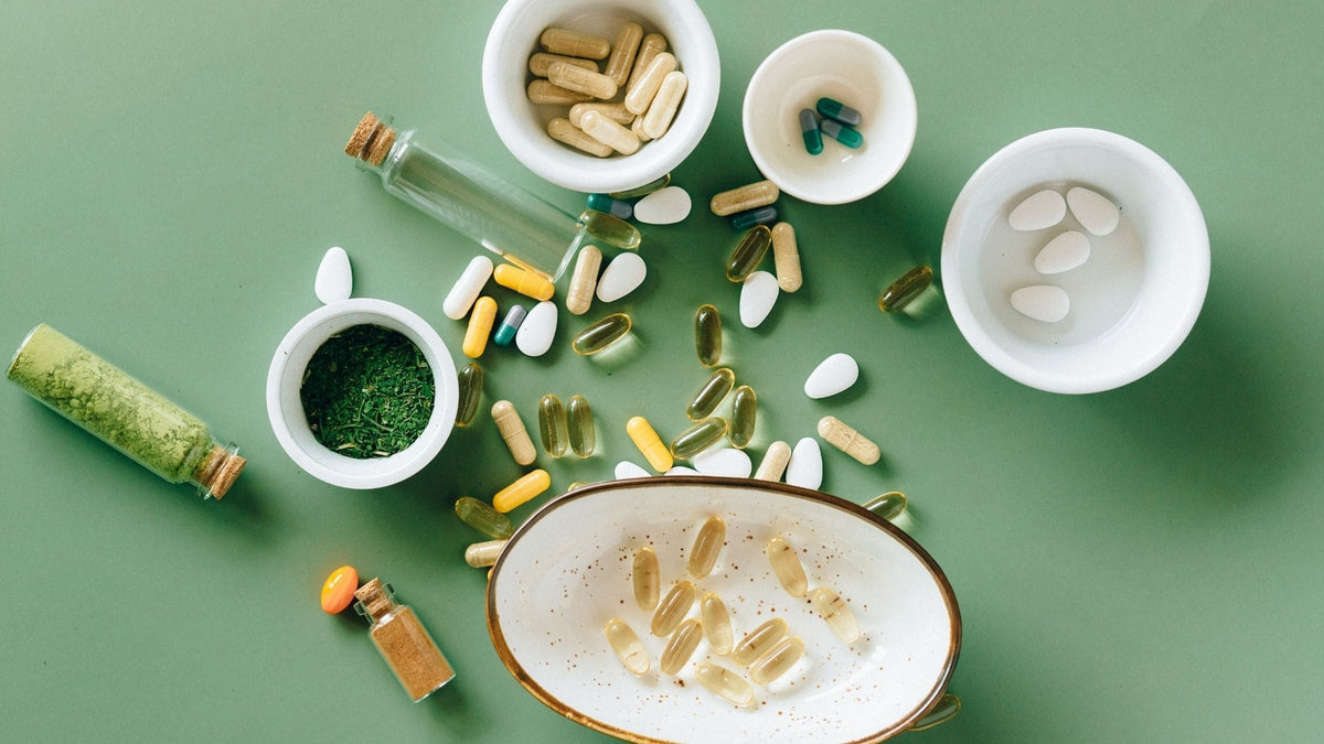 Variety of collagen supplements pills powder on green background in bowls