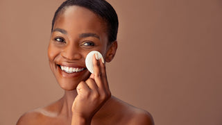 Young woman wiping skin with pad