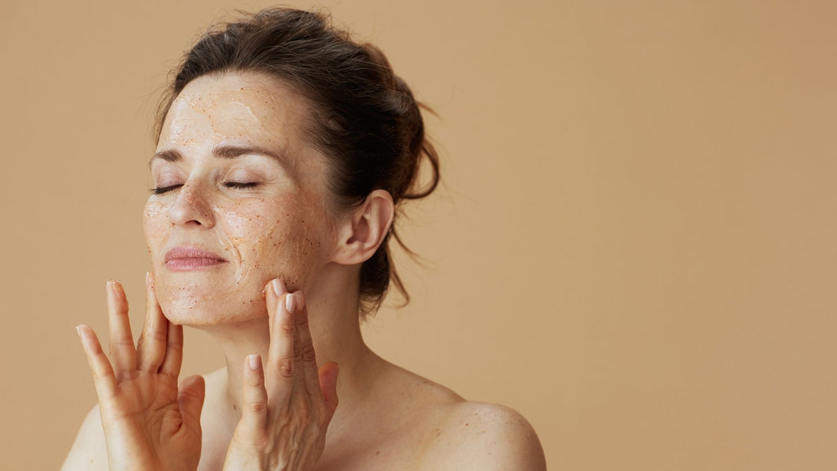 modern woman with face scrub against beige background