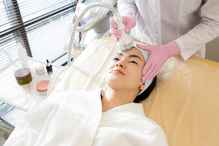 High angle portrait of Asian woman enjoying facial care in cosmetologist office