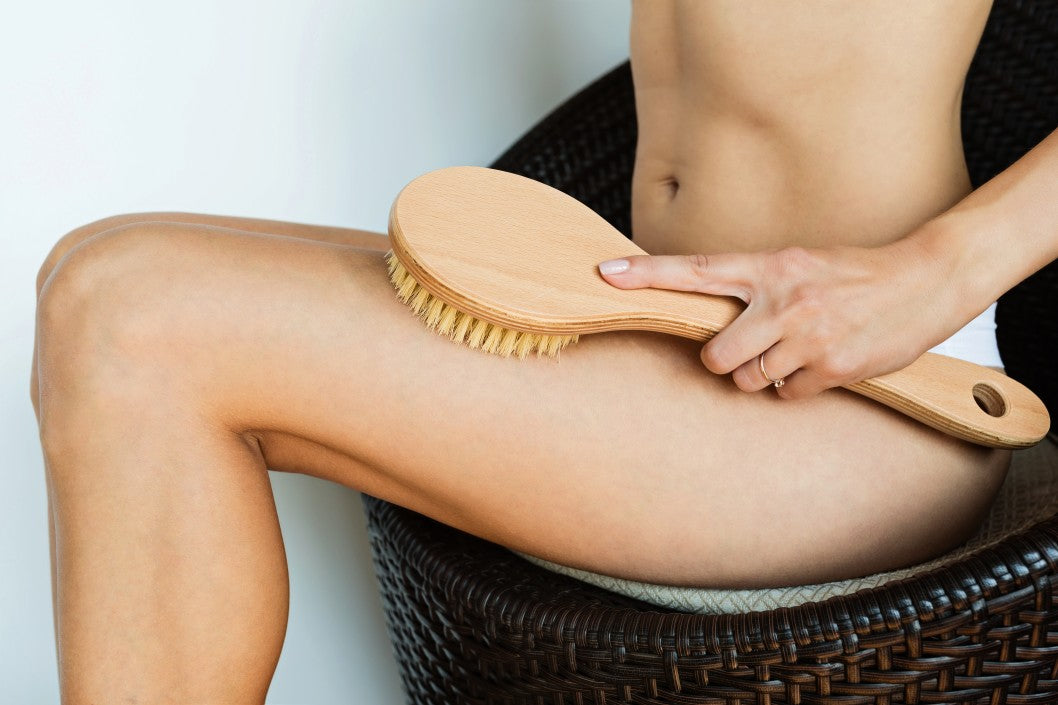Woman scrubbing legs with exfoliating cream